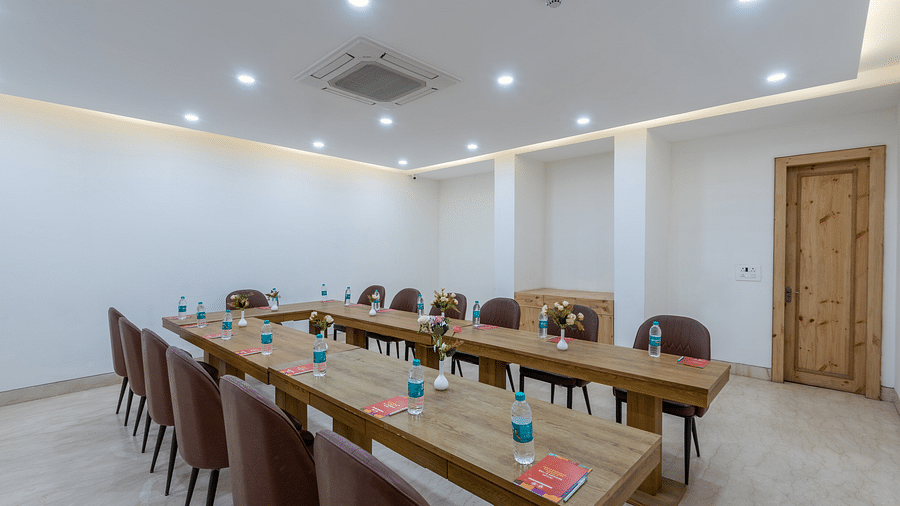 Side view of a conference room featuring two long tables arranged with chairs, set up for a meeting or event at DLS The Classio